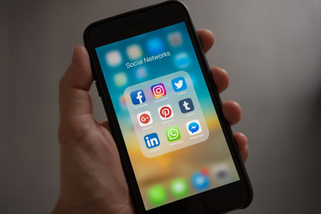 Phone showing various social media apps, illustrating channels used to send notifications and real-time updates.